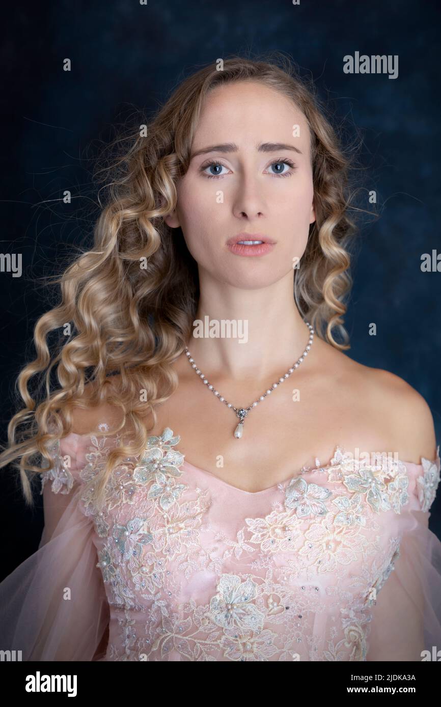 Una principessa da favola con capelli biondi e vestito di rosa Foto Stock