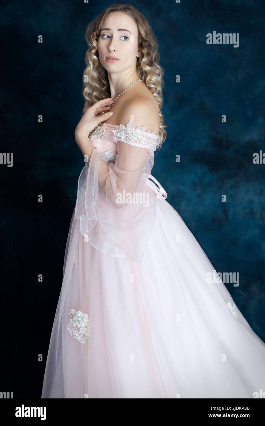 Una principessa da favola con capelli biondi e vestito di rosa Foto Stock