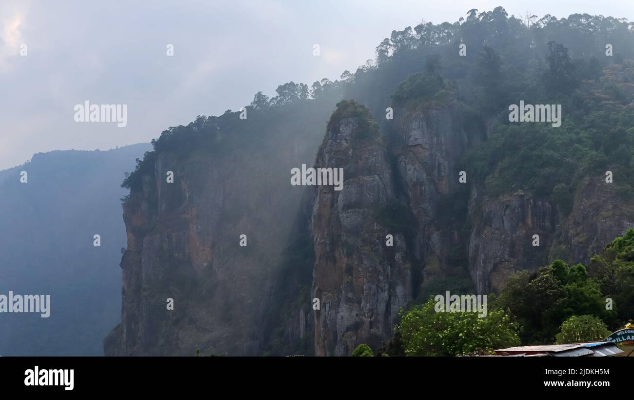 Vista delle rocce a colonna con tre massi posizionati verticalmente che raggiungono un'altezza di 400 piedi in serata, Kodaikanal, Tamilnadu, India. Foto Stock