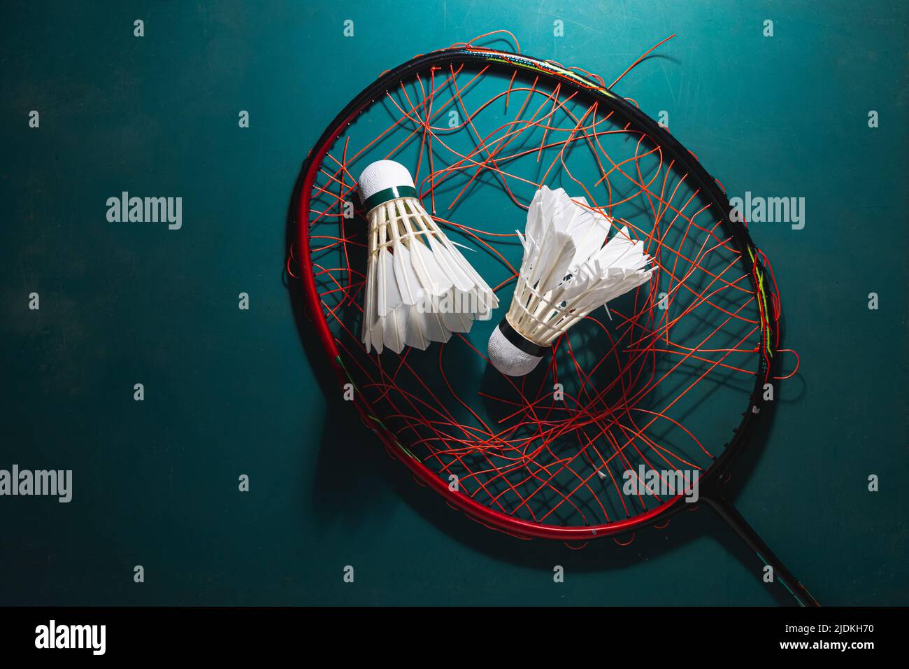 badminton shuttleock con racchetta badminton che rompe le corde sul pavimento in gomma del cortile. Foto Stock