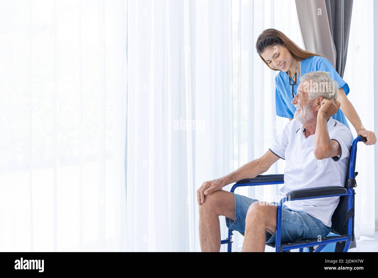 uomo anziano anziano seduto su sedia a rotelle con assistenza infermieristica sorriso felice in ospedale assistenza domiciliare. Foto Stock