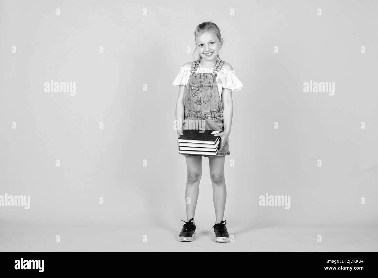 Alla pausa scolastica. Bella ragazza teen con libri. Bambino come la lettura. Notebook per fare appunti. Letteratura per bambini. Ritorno a scuola. Felice Foto Stock