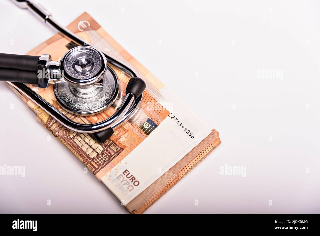 Costi sanitari immagine concettuale: Stetoscopio e cumulo di denaro su una carta medica, simbolo dei costi sanitari o assicurazione sanitaria, isolato sopra Foto Stock