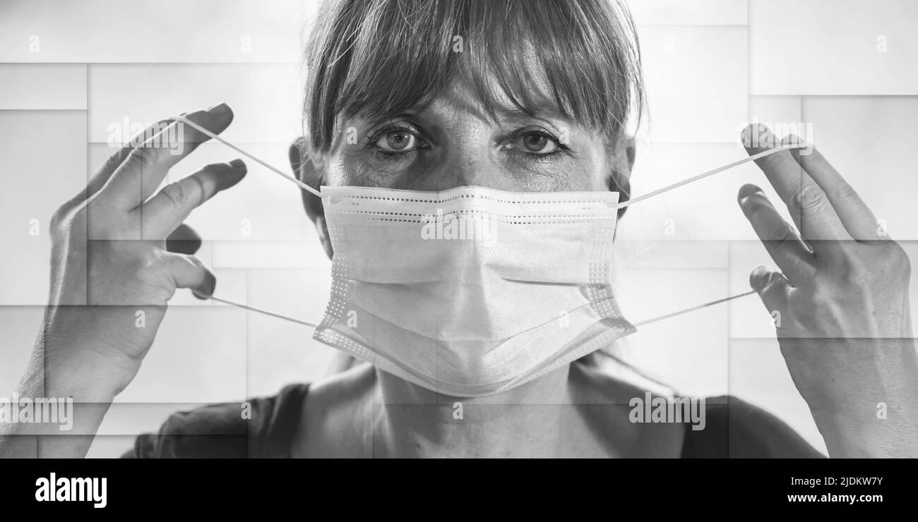 Ritratto di donna matura che mette su una maschera medica sul suo viso, modello geometrico Foto Stock