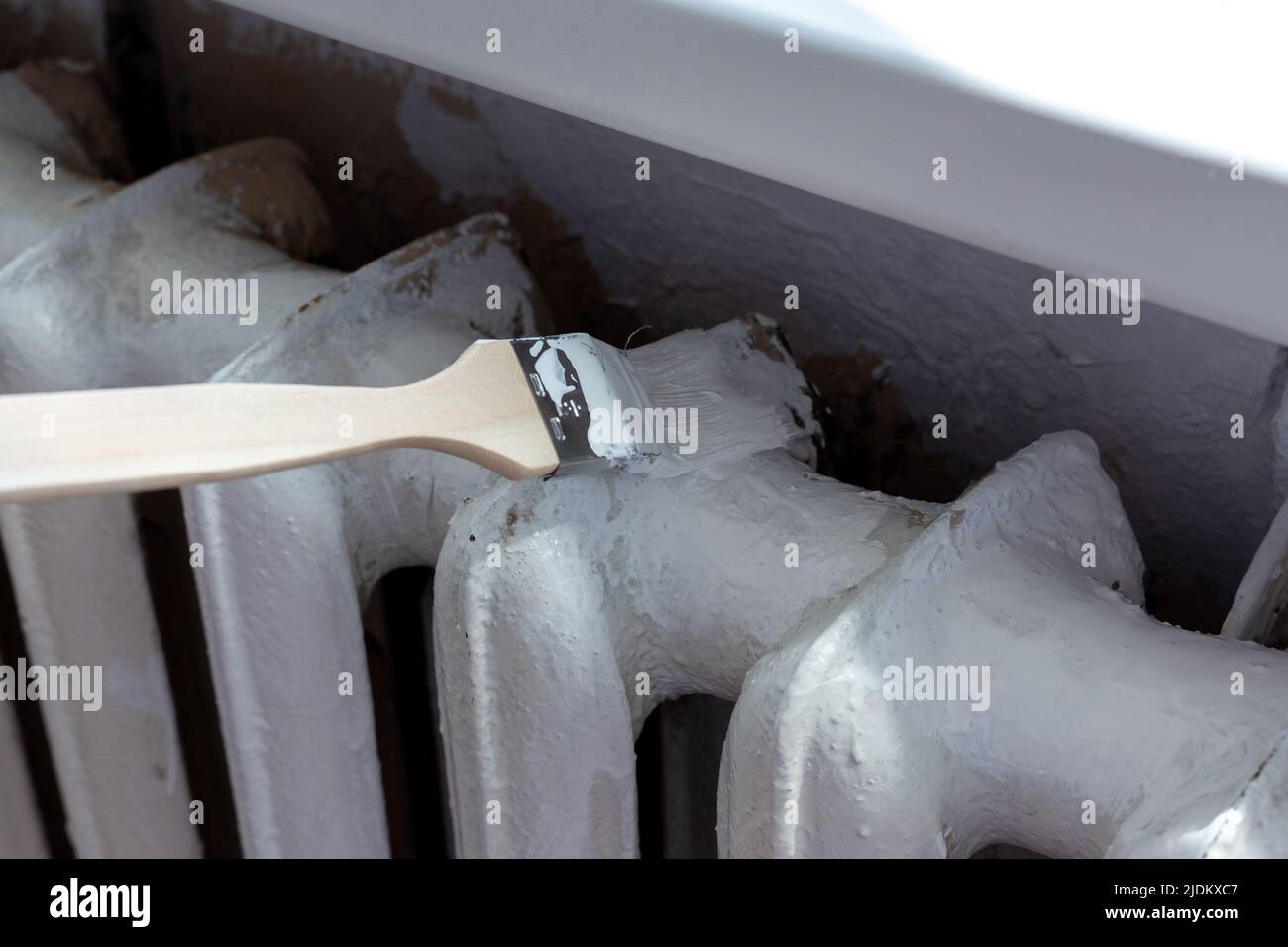 Verniciatura dei radiatori con una spazzola speciale. Verniciatura della batteria. Foto Stock