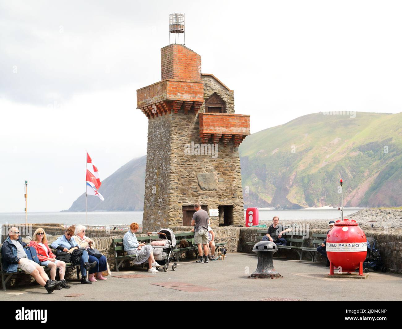 Persone sedute su panchine al mare a Lynmouth, Deveon, Regno Unito Foto Stock