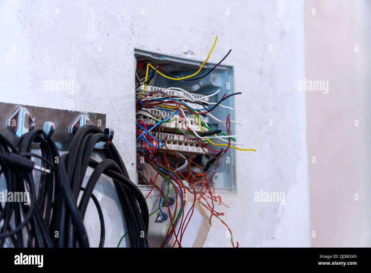 Aprire la scatola di derivazione con fili sporgenti, predisposti per il montaggio e il collegamento dei cavi telefonici e del computer. Messa a fuoco selettiva Foto Stock