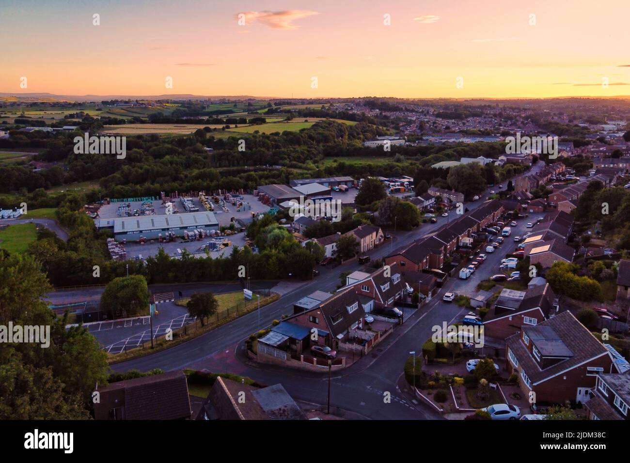 Drone urbano immagine di alloggi tipici del Regno Unito. Tramonto con case in mattoni rossi e zona industriale Foto Stock
