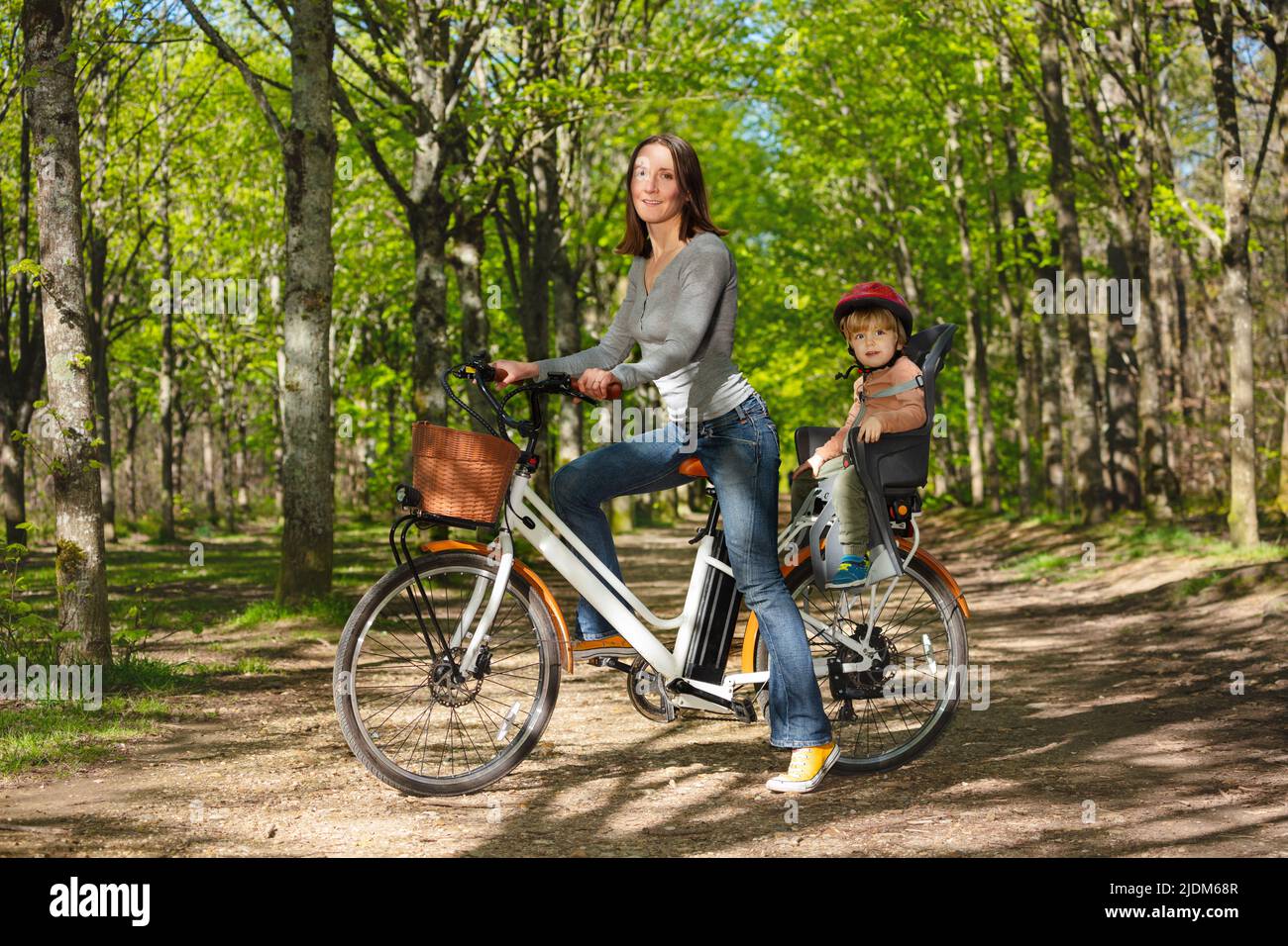 Madre con un bambino in bicicletta elettrica nel parco Foto Stock