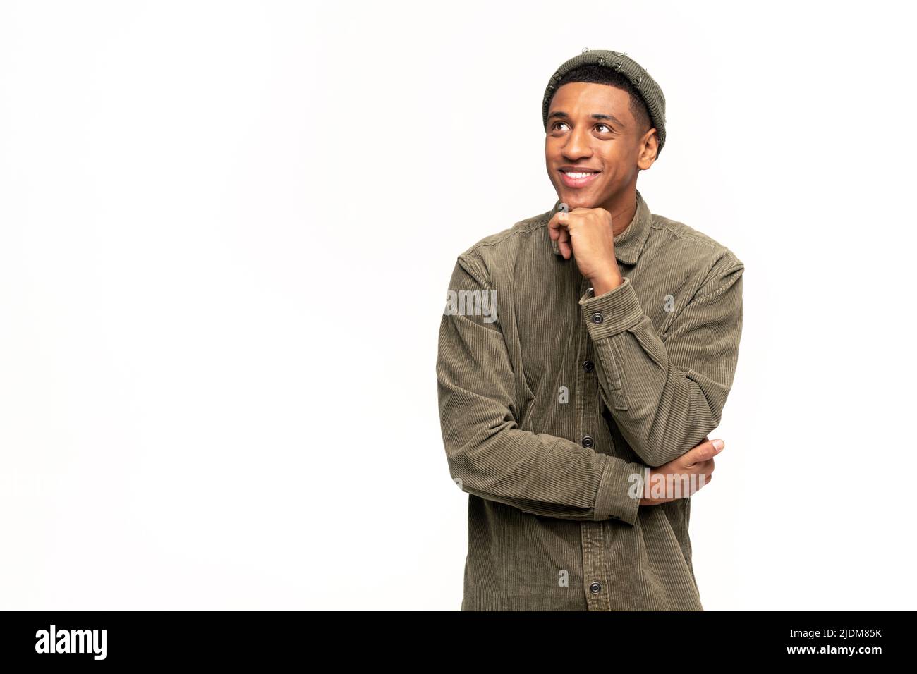 Ritratto di felice soddisfatto bel giovane uomo in camicia in piedi con le braccia incrociate e guardando via con un sorriso toothy. Studio interno girato su sfondo bianco Foto Stock