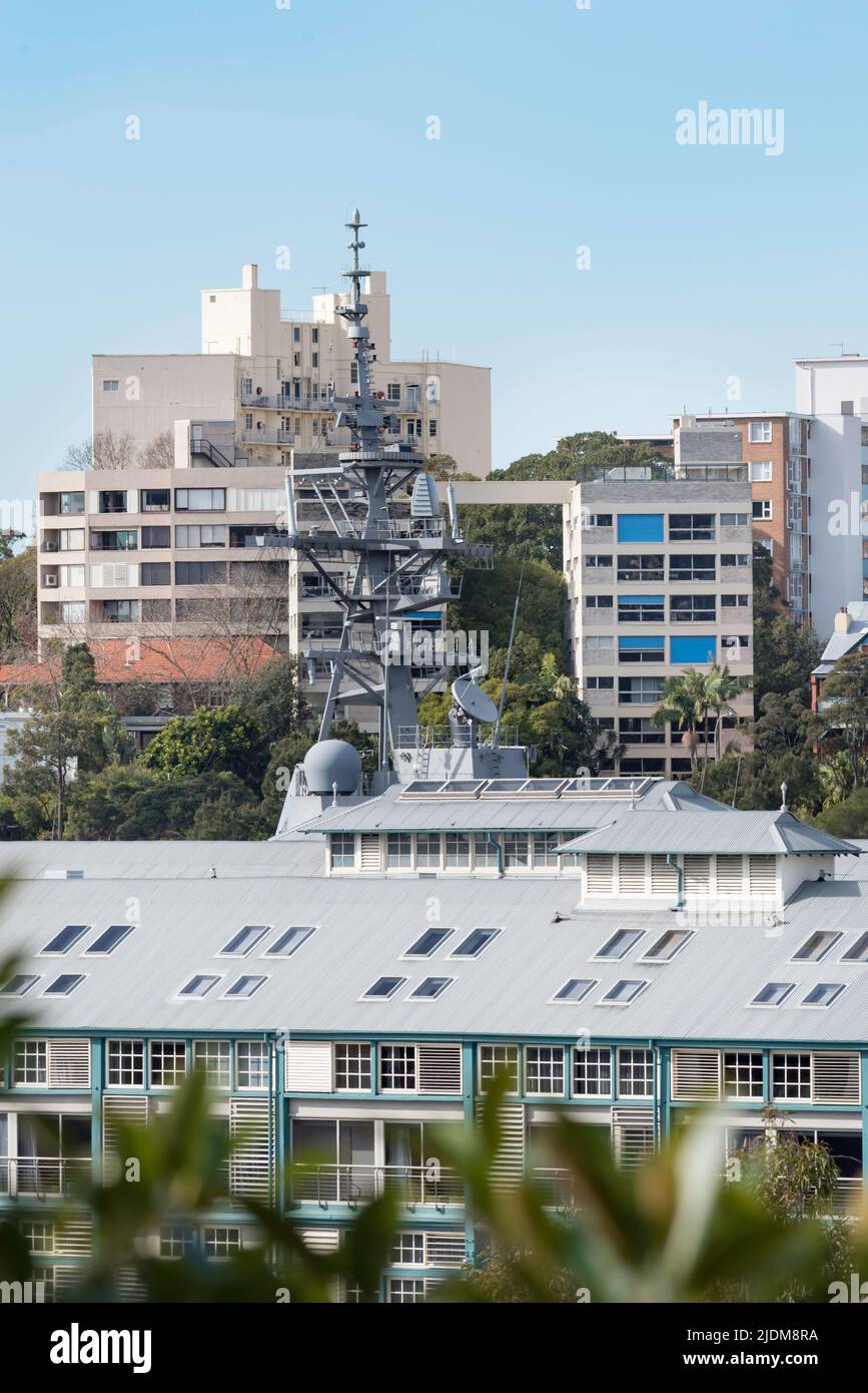 L'albero di una Marina Australiana, cacciatorpediniere di guerra aerea di classe Hobart sorge sul tetto dell'hotel e sul Finger Wharf a Woolloomooloo Bay, Sydney Foto Stock