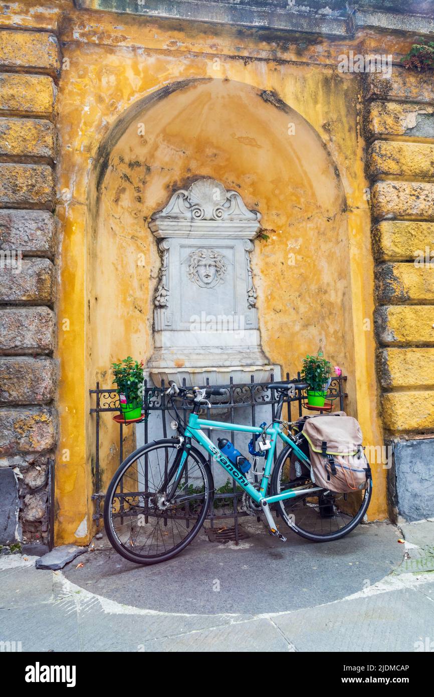 Natura morta, scena colorata di una bicicletta di fronte ad una piccola fontana nel centro storico di Genova, Genova, Liguria, Italia Foto Stock