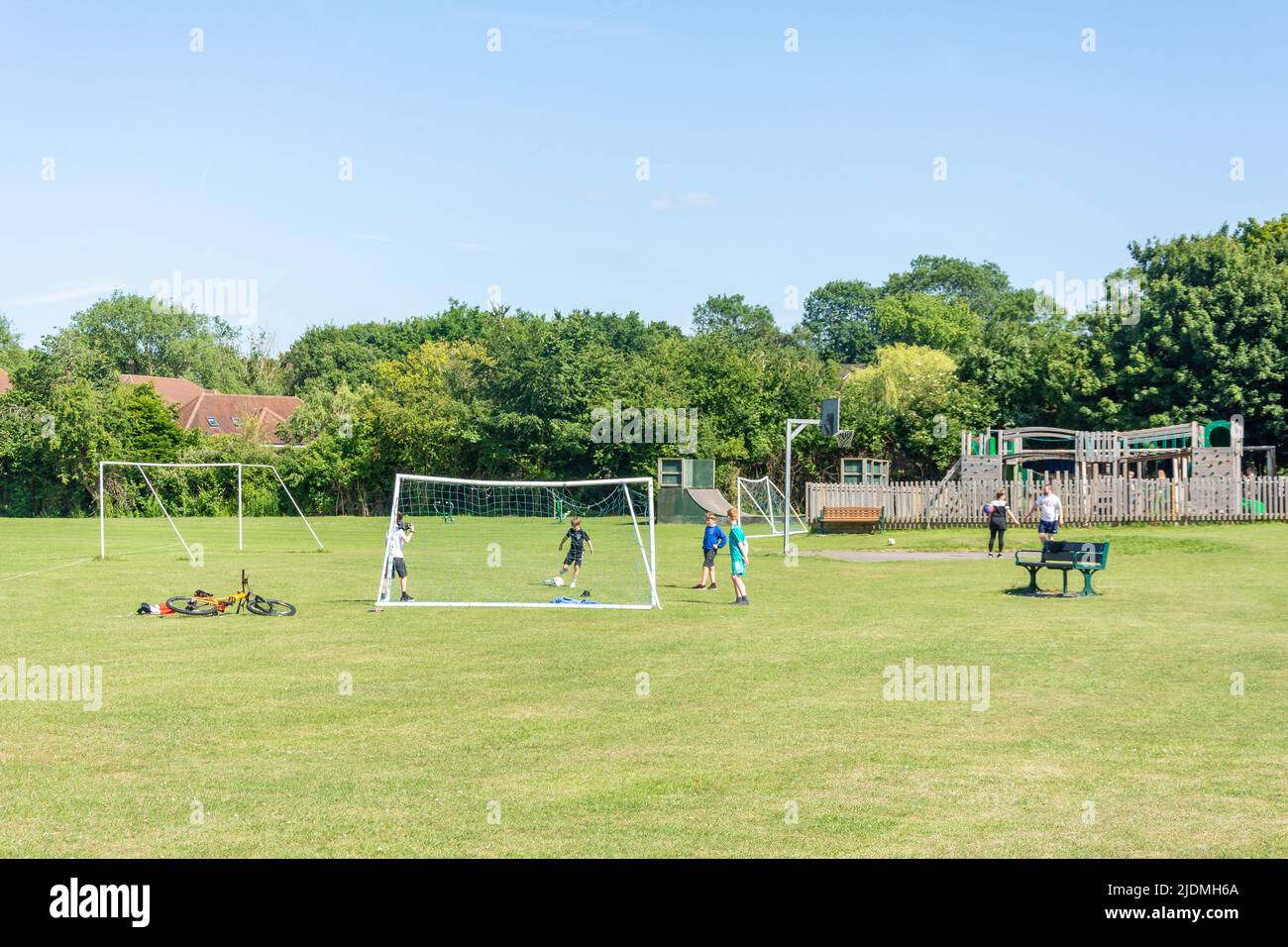 Bambini che giocano a calcio sul Green, High Street, Tetsworth, Oxfordshire, Inghilterra, Regno Unito Foto Stock