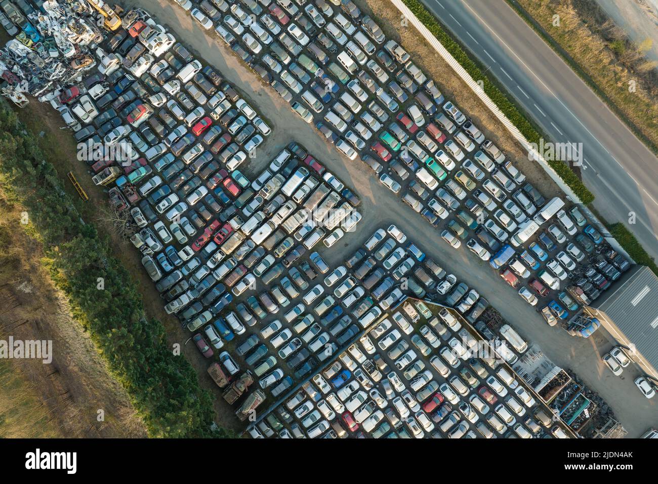 Vista aerea del grande parcheggio di junkyard con file di auto scartate rotte. Riciclaggio dei vecchi veicoli Foto Stock