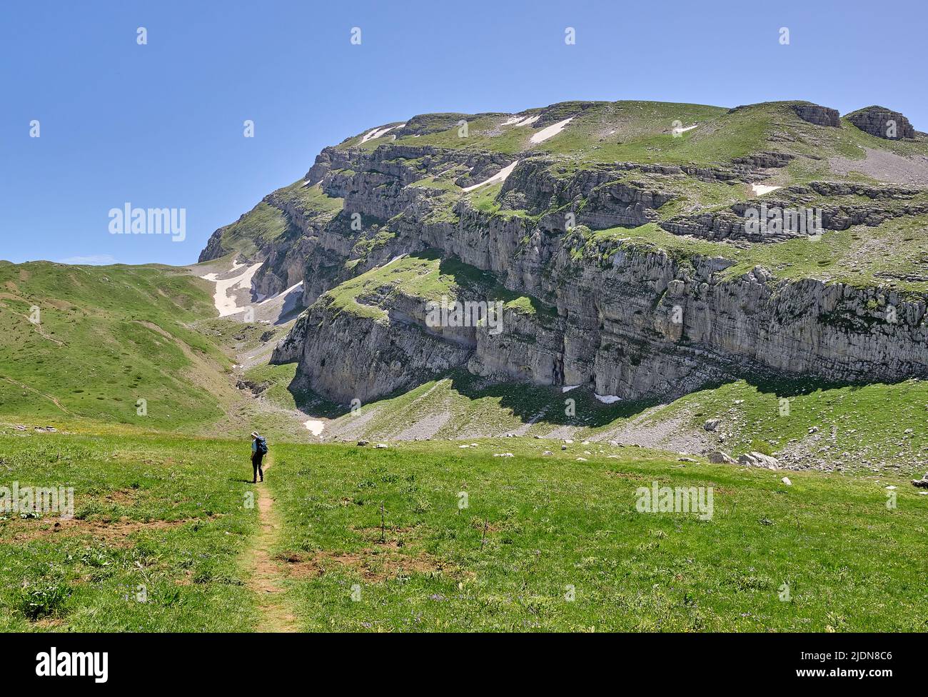 Camminando attraverso l'alto pascolo alpino sulla passeggiata del Lago del Drago sul Monte Timfi nella regione di Zagori nel nord della Grecia Foto Stock