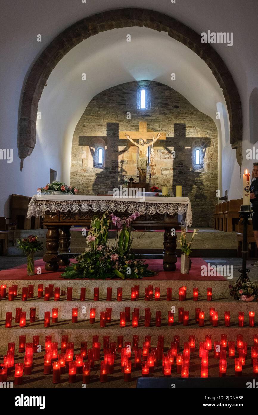 Spagna, Galizia, o Cebreiro. Chiesa di Santa Maria la Real. Candele di preghiera e altare. Foto Stock