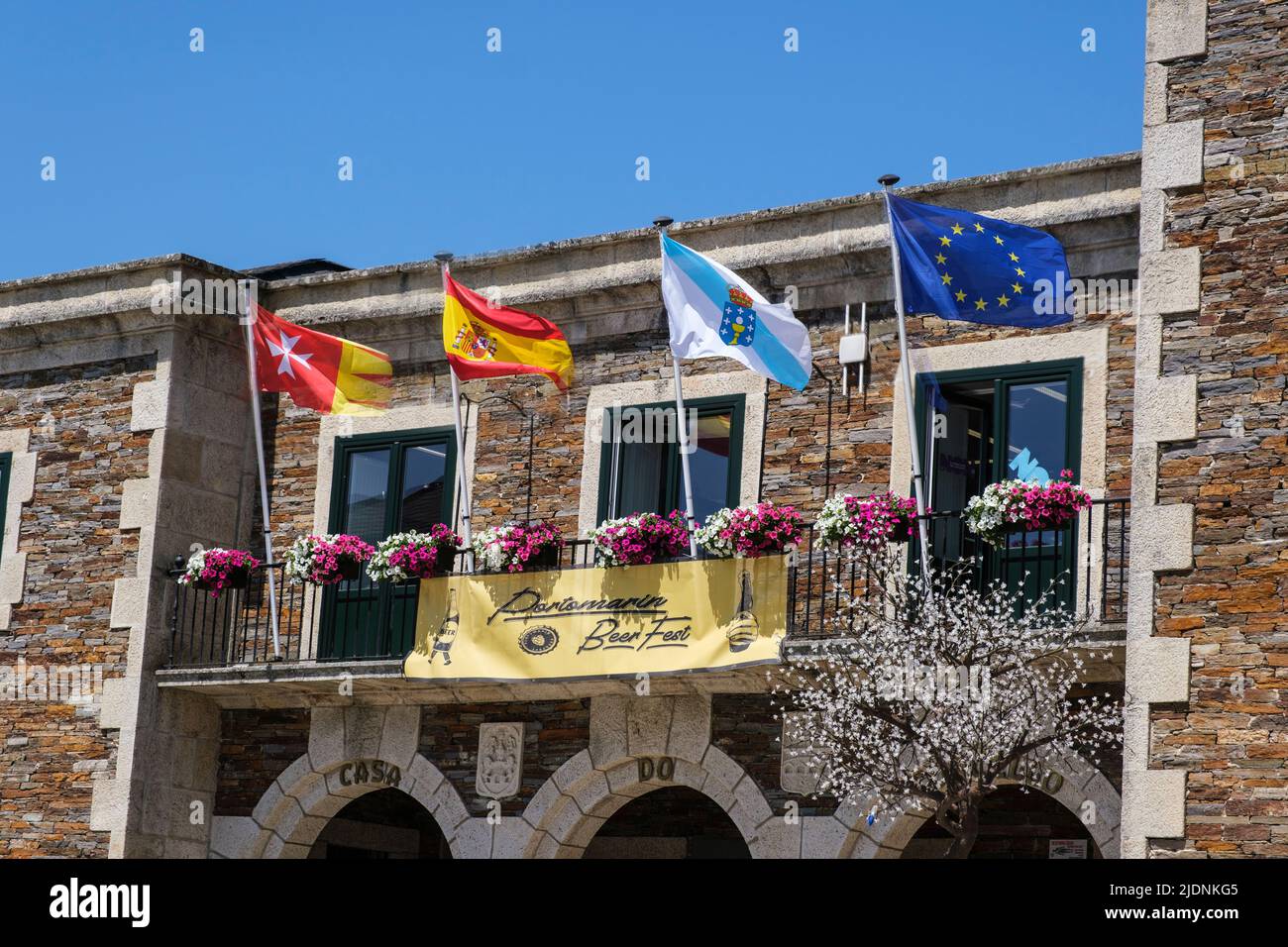 Spagna, Portomarin, Galizia. Bandiere di Portomarin, Spagna, Galizia e Unione europea, da sinistra a destra. Foto Stock