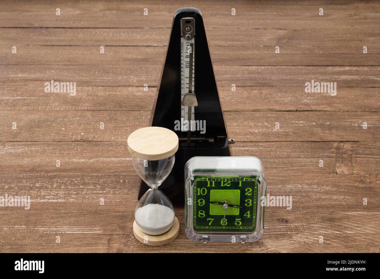 Immagine di un orologio da tavolo una clessidra e un metronomo, rappresentazione del passare del tempo. Foto Stock