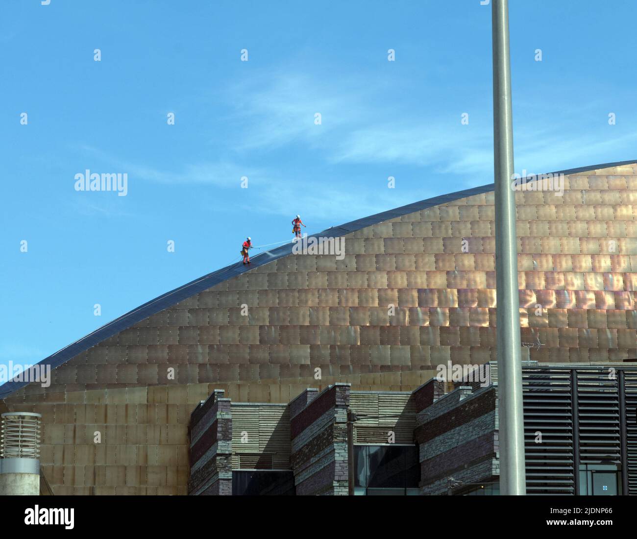 Operai che puliscono il tetto in rame della sala concerti Millennium Centre, Cardiff Bay. Giugno 2022 Foto Stock