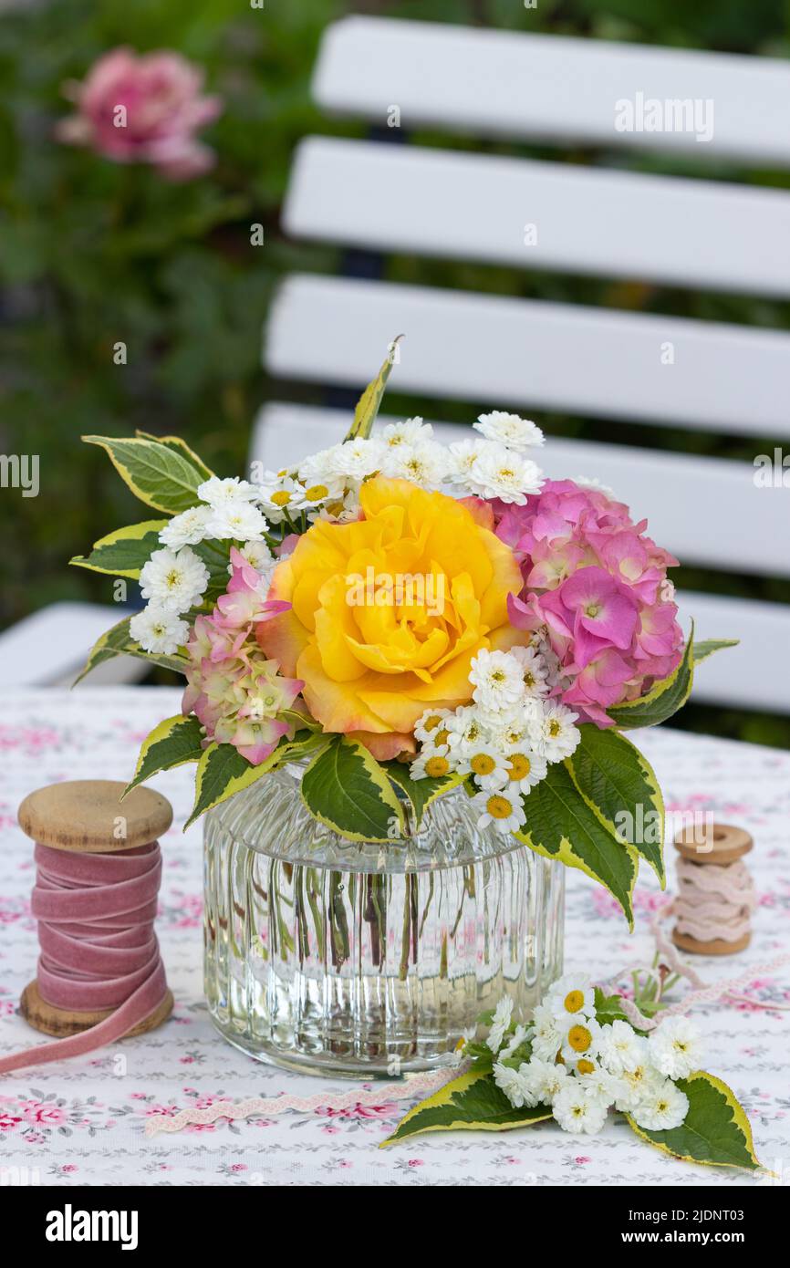 romantico bouquet di rose gialle e fiori di hydrangea in vaso di vetro Foto Stock