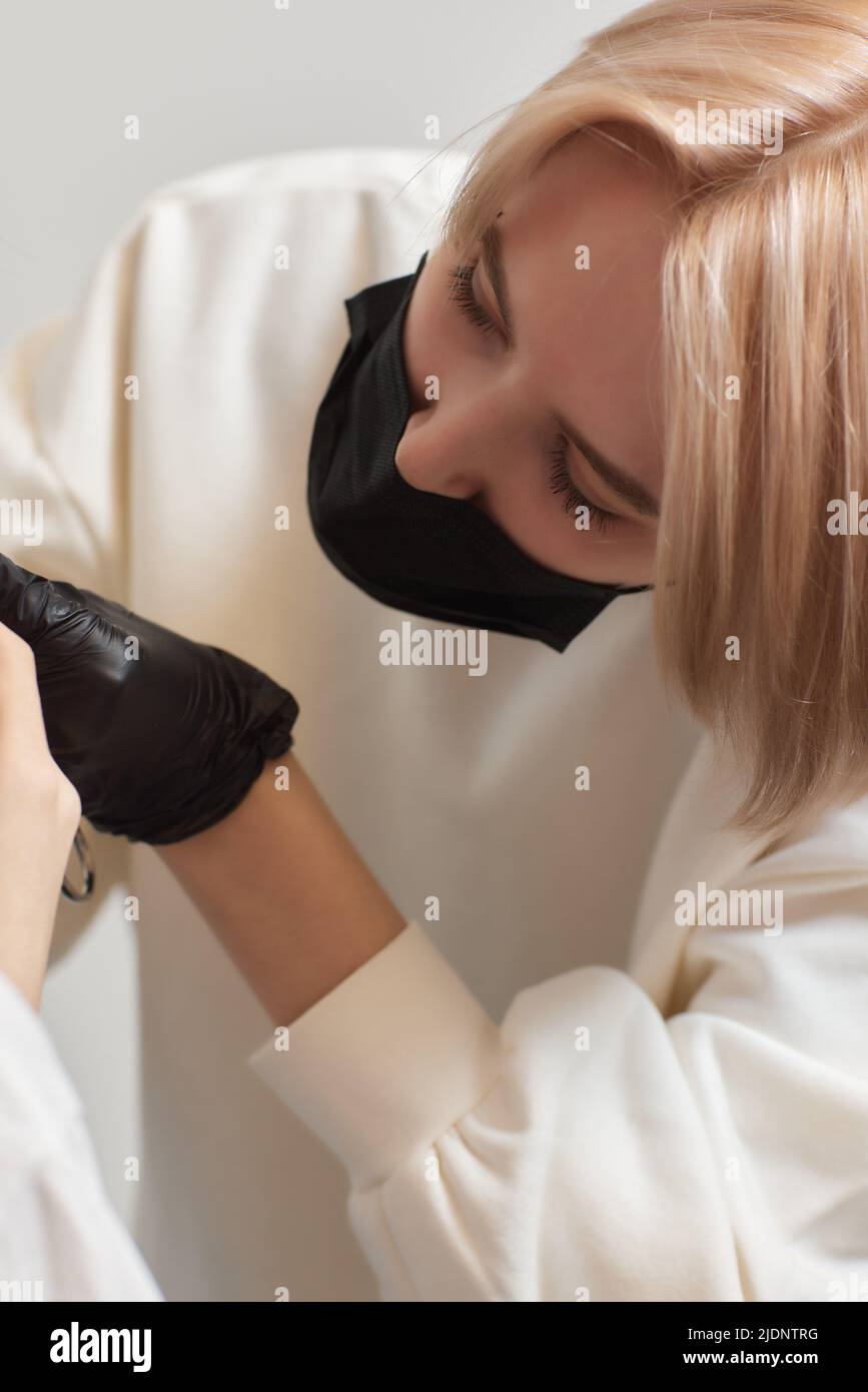 Operazione di piercing della linguetta professionale che tiene il gioiello Foto Stock