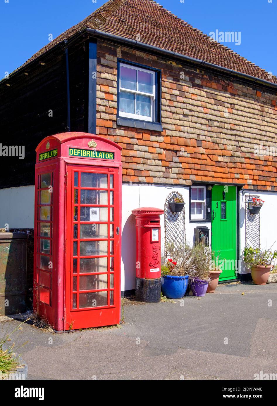 La vecchia scatola del telefono ora ospita un defibrillatore, Coronation Square, Lydd, Kent, Regno Unito Foto Stock