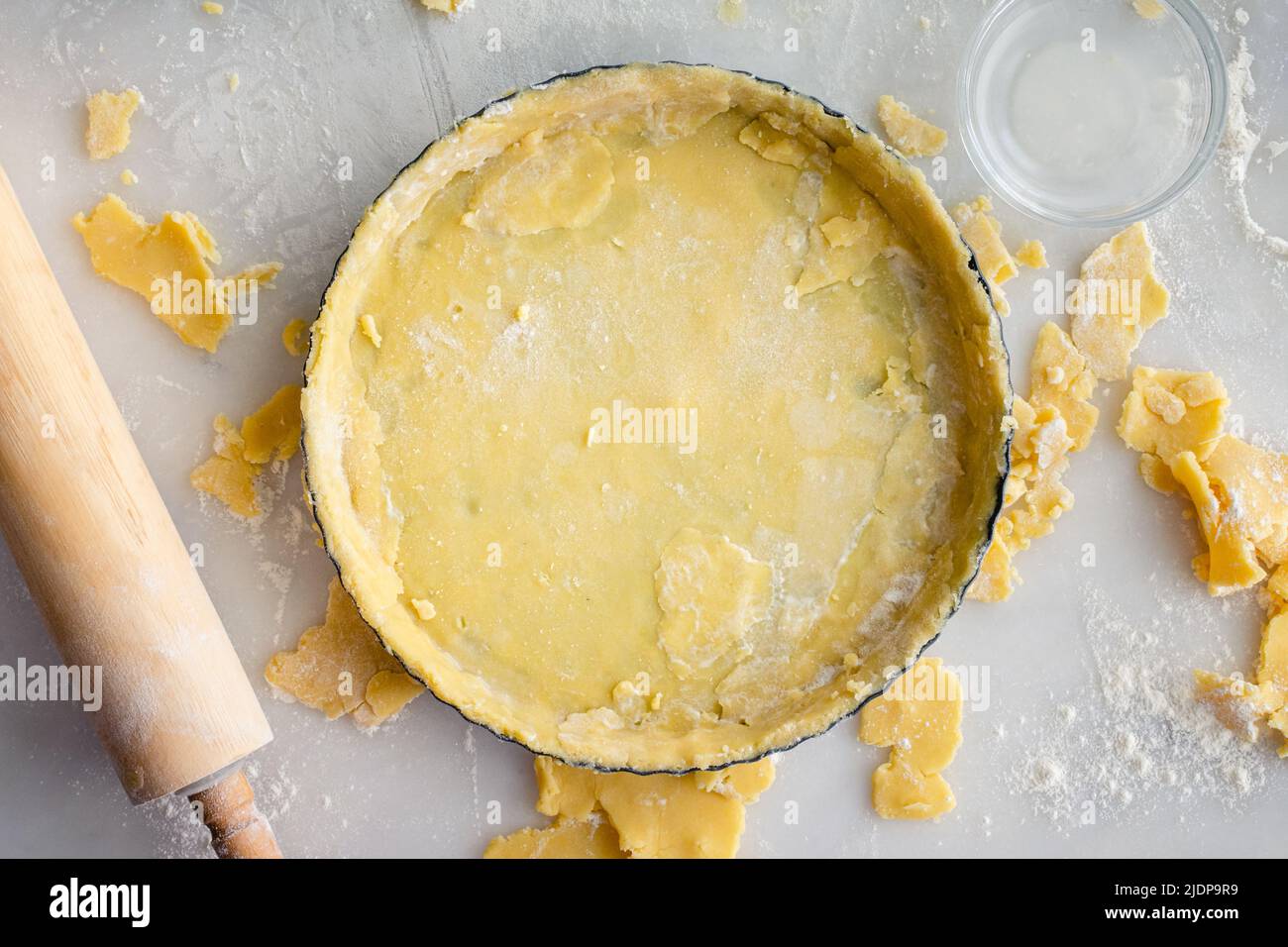Torta Pan ripiena di pasta cruda: Crosta di torta cruda in una teglia mostrata con un matterello Foto Stock