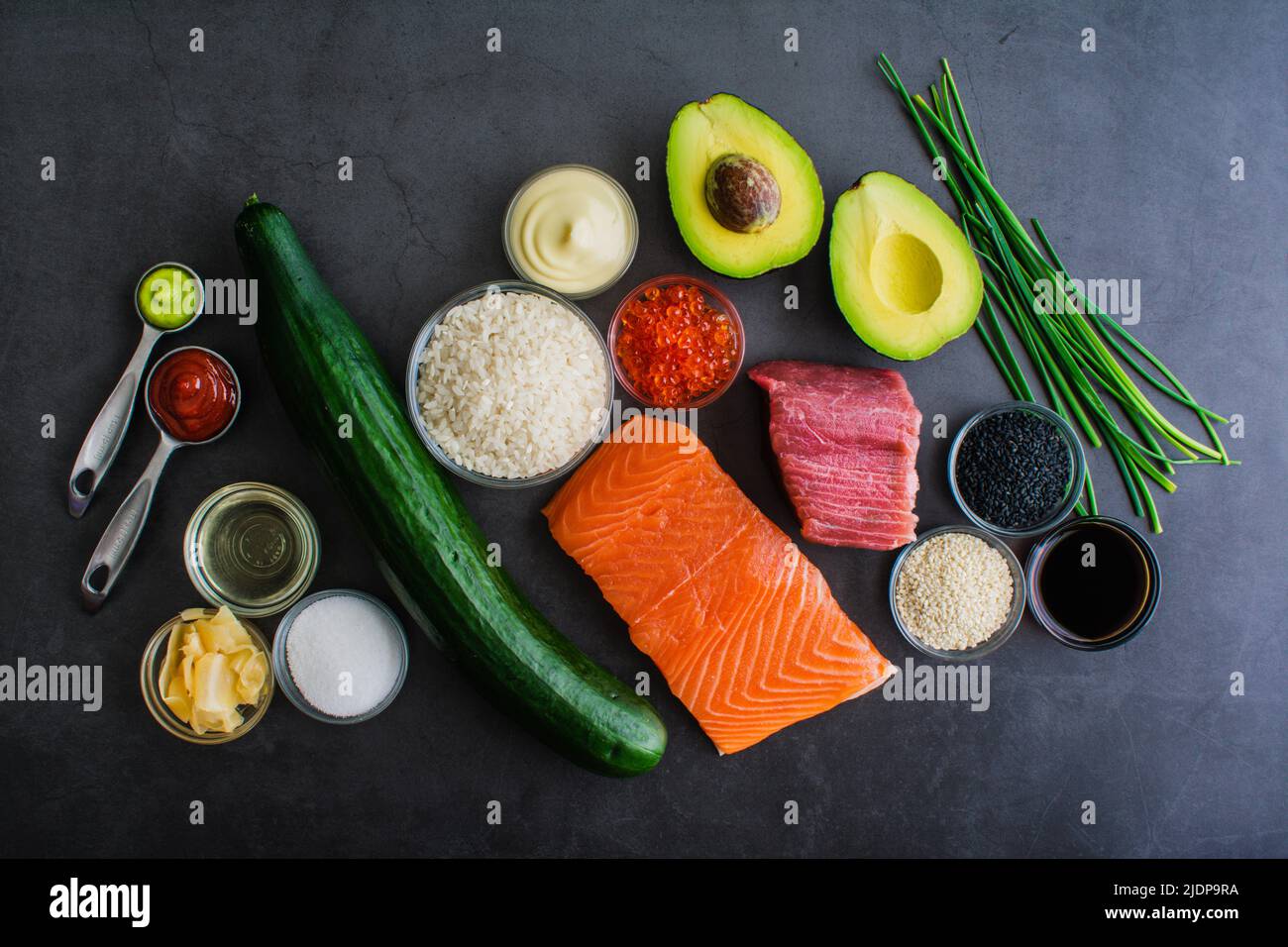 Ingredienti per ciambelle di sushi preparate con salmone, tonno, riso e verdure: Pesce fresco, uova di salmone e altri ingredienti per sushi Foto Stock
