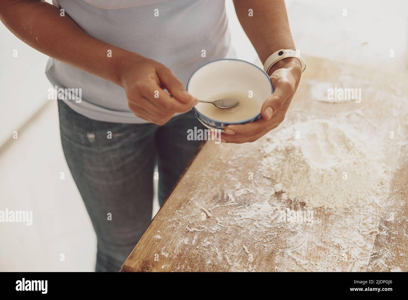 Impastare l'impasto con l'aggiunta di uova per preparare la pizza a casa Foto Stock