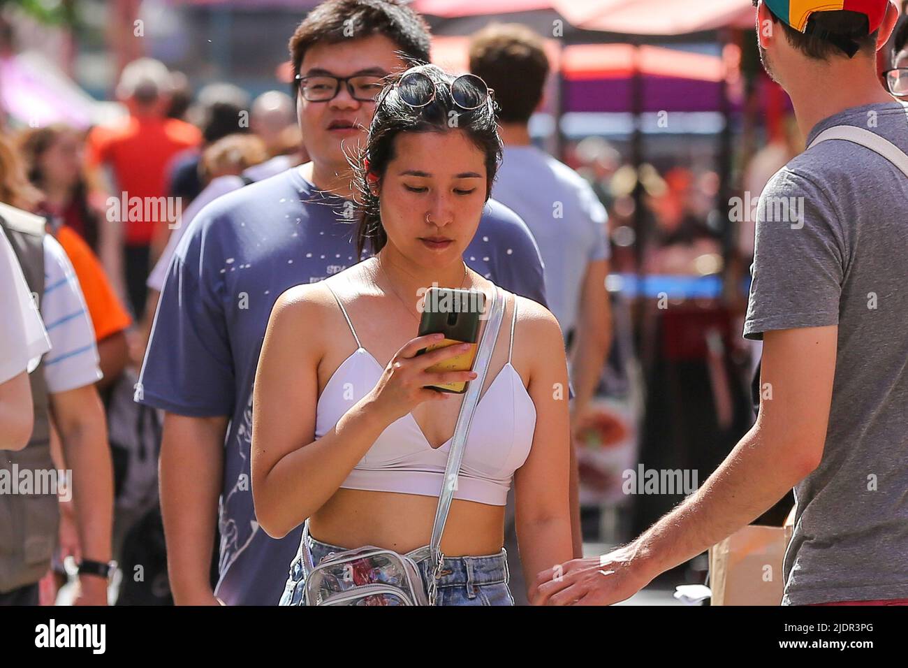 Londra, Regno Unito. 17th giugno 2022. Una donna guarda il suo telefono cellulare mentre cammina a China Town. (Foto di Dinendra Haria/SOPA Images/Sipa USA) Credit: Sipa USA/Alamy Live News Foto Stock
