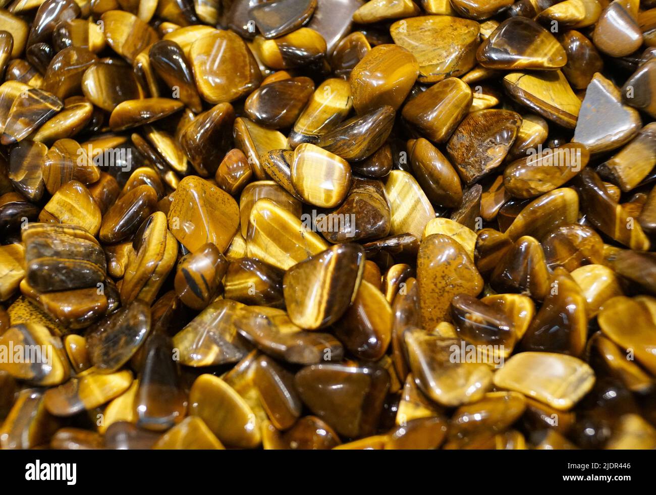 Un mucchio del colore giallo e marrone lucido delle rocce dell'occhio della tigre Foto Stock