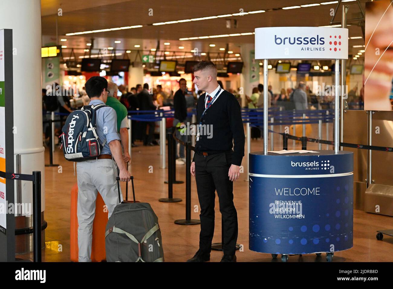 L'illustrazione mostra un viaggiatore e un lavoratore delle compagnie aeree di Bruxelles nella sala partenze dell'aeroporto di Bruxelles, a Zaventem, giovedì 23 giugno 2022. Piloti e membri dell'equipaggio di cabina delle compagnie aeree belghe Brussels Airlines e della compagnia low-cost Ryanair iniziano uno sciopero di tre giorni. Durante i tre giorni di sciopero la compagnia aerea Brussels Airlines deve cancellare circa il 60% del suo orario di volo di linea. 315 voli sono stati annullati, 40.000 passeggeri sono stati interessati. L'equipaggio di cabina e i piloti vanno in sciopero contro, tra le altre cose, la pressione di lavoro che stimano troppo alta. Ryanair si pensa che cance Foto Stock