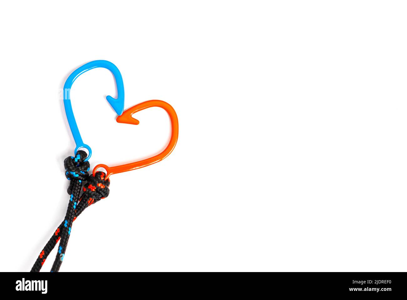 Forma a cuore realizzata con due bracciali a corda intrecciata e fishhook disposti su sfondo bianco con spazio per la copia. Foto Stock