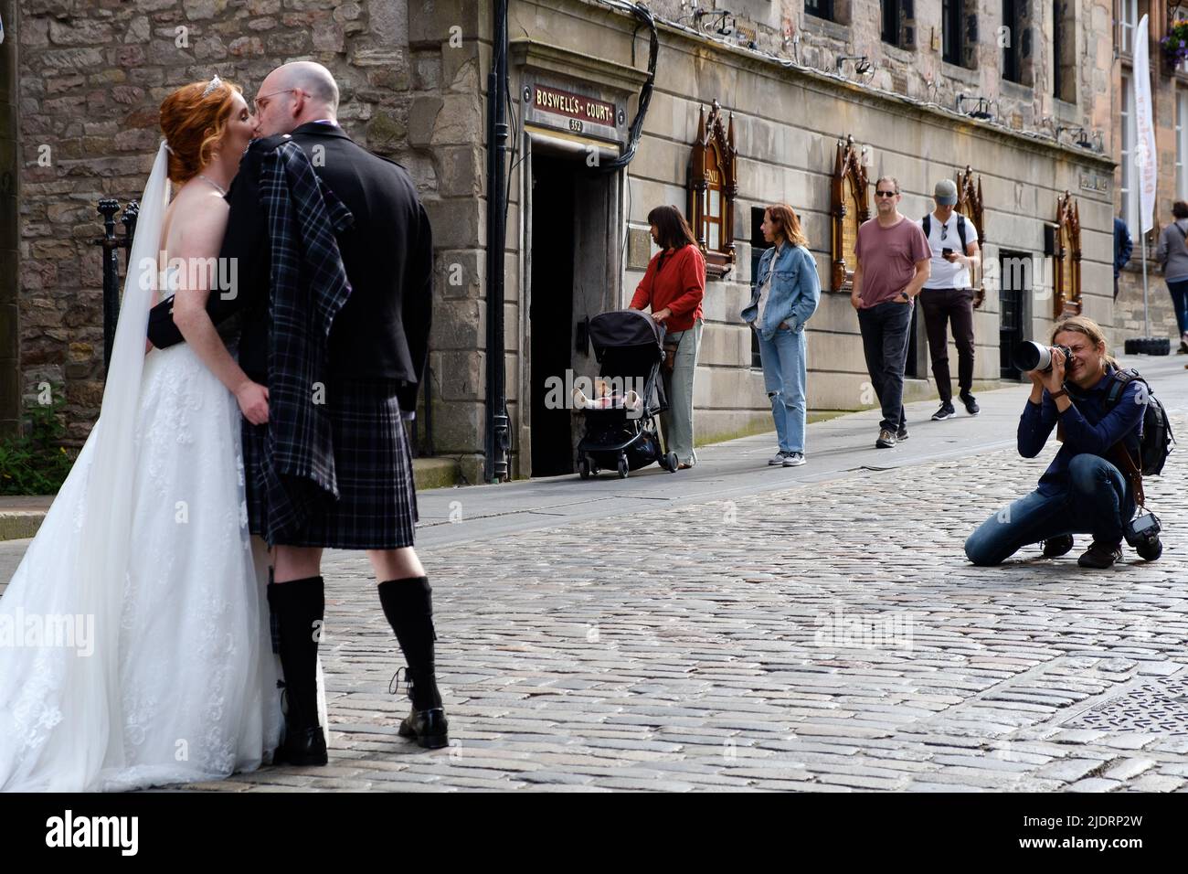 Matrimonio bacio - una coppia sposata di recente che ha foto di matrimonio scattate sul Royal Mile di Edimburgo, vicino al Castello di Edimburgo Foto Stock