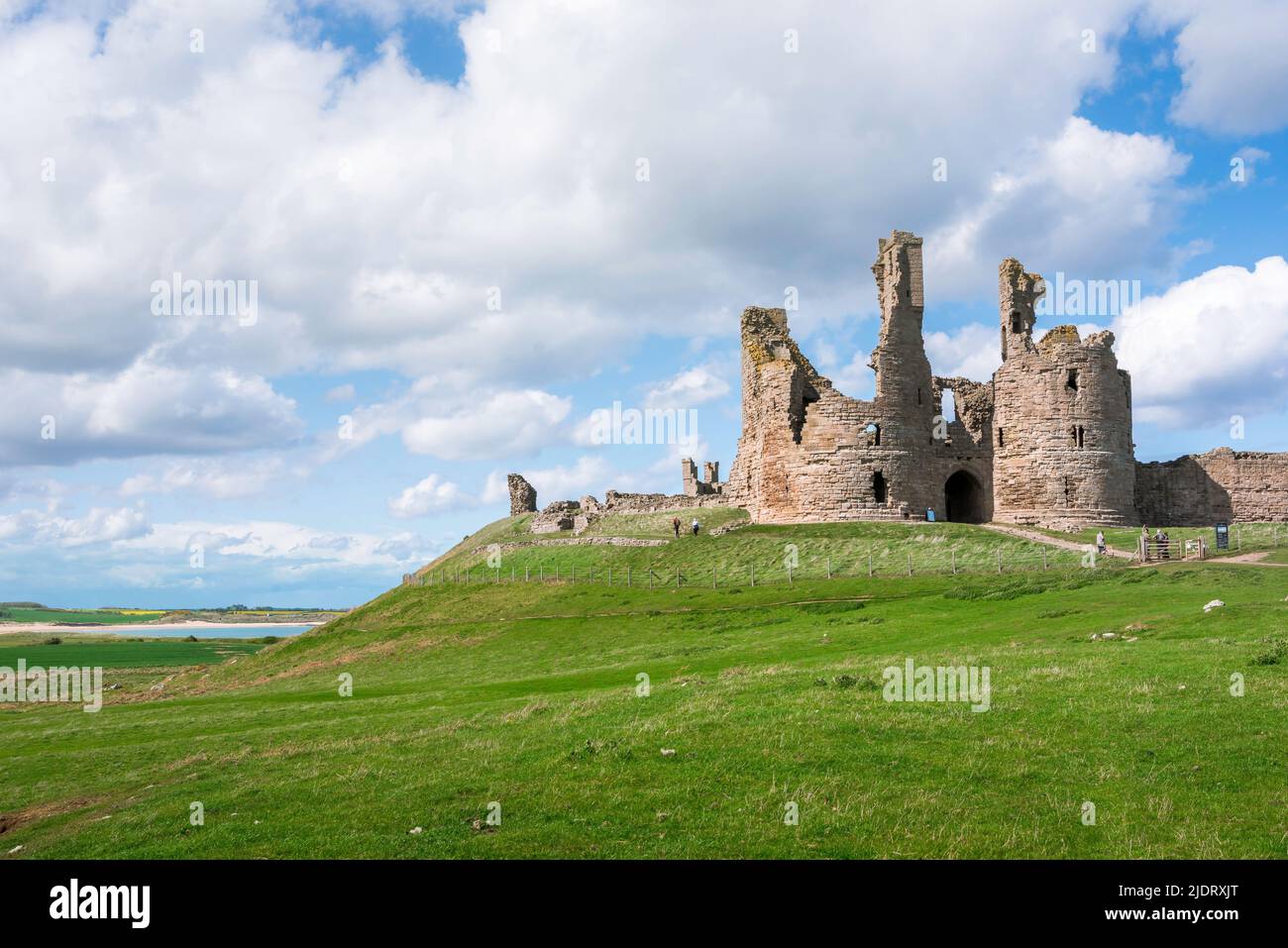Castello di Dunstanburgh, vista nella tarda primavera del castello di Dunstanburgh del 14th secolo in rovina, situato sulla costa del Northumberland vicino a Embleton Bay, Inghilterra Foto Stock