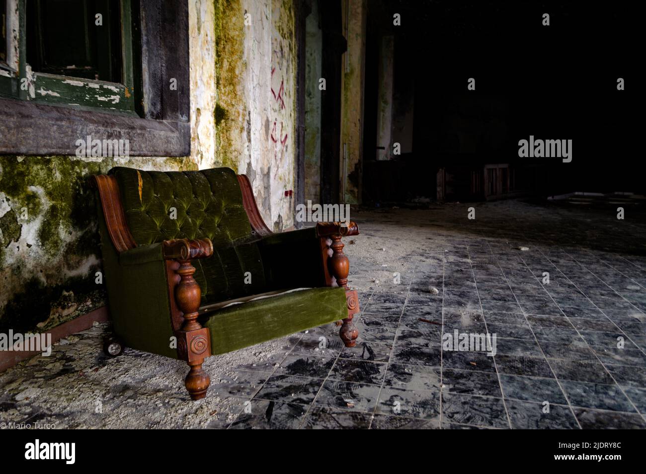 Un divano verde in un edificio abbandonato Foto Stock