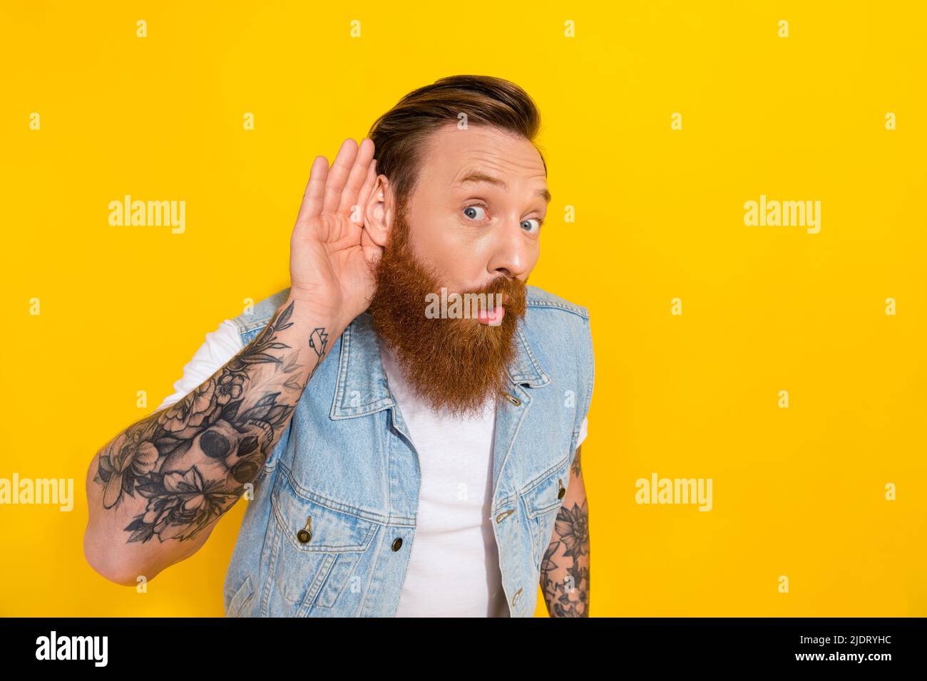 Foto della giovane persona braccio tenere vicino all'orecchio ascoltare eavesdrop interessato isolato su sfondo giallo Foto Stock