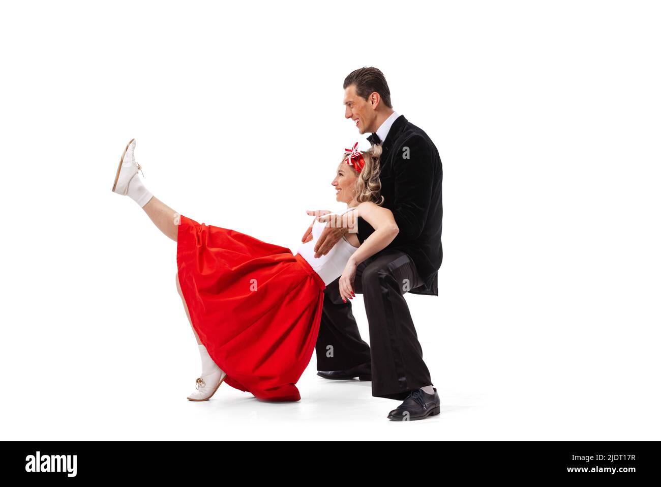 Ritratto dinamico di coppia danzante in vintage stile abiti danzanti, saltando isolato su sfondo bianco. Arte, musica, moda, danza shcool concetto Foto Stock