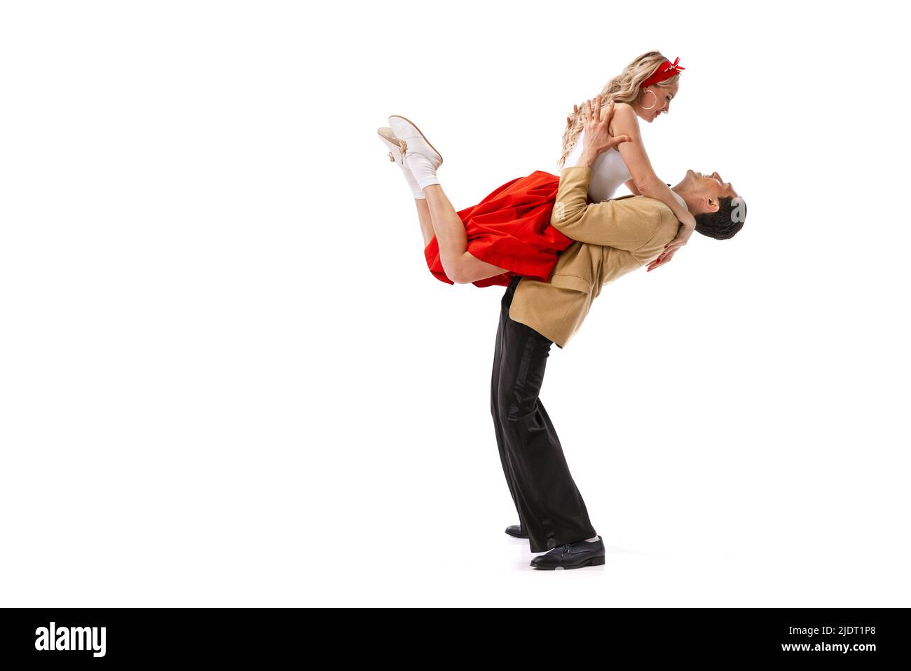 Ritratto dinamico di coppia danzante in vintage stile abiti danzanti, saltando isolato su sfondo bianco. Arte, musica, moda, danza shcool concetto Foto Stock