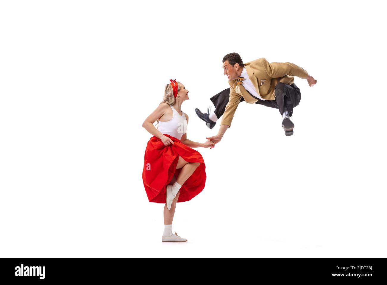 Ritratto dinamico di coppia danzante in vintage stile abiti danzanti, saltando isolato su sfondo bianco. Arte, musica, moda, danza shcool concetto Foto Stock