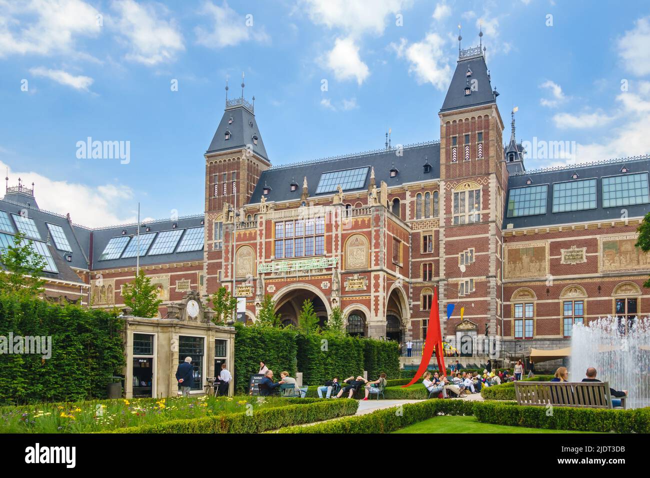AMSTERDAM, PAESI BASSI - 26 GIUGNO 2014: Vista al Rijksmuseum con i turisti seduti nel giardino del museo di Amsterdam, Paesi Bassi Foto Stock