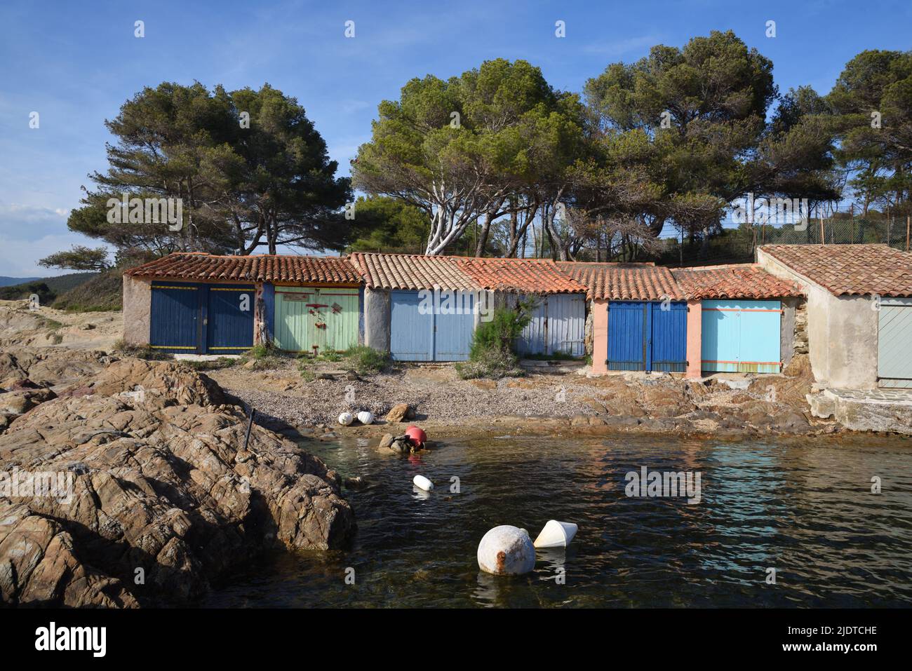 Colorato Old Boatsheds sulla riva vicino alla spiaggia o Plage de Bregancon di fronte Breganon Fort & Island Bormes-les-Mimosas Var Provence france Foto Stock