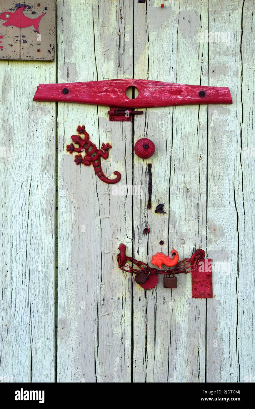 Old Shed porta decorata con metallo Junk tra cui Toy Metal Lizard e Old Rake testa sulla barca Shed sulla Bregancon Beach Var Provenza Francia Foto Stock