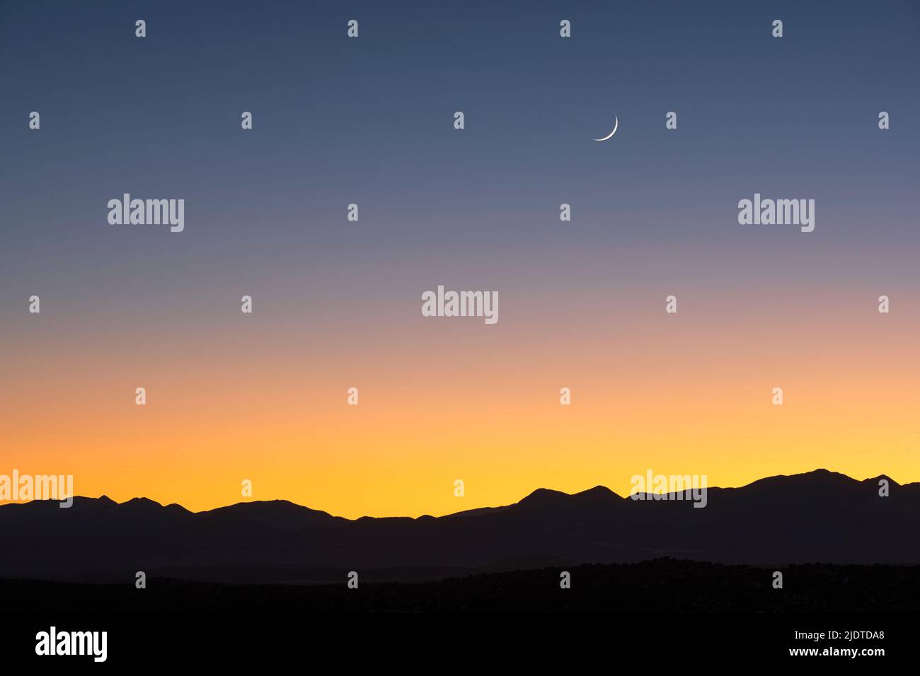 USA, New Mexico, Santa Fe, Jemez Mountains al crepuscolo con luna crescente sul cielo Foto Stock
