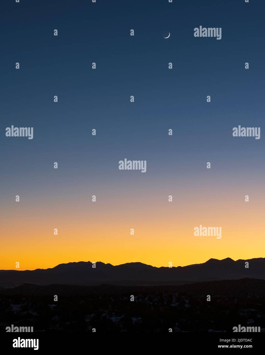 USA, New Mexico, Santa Fe, Jemez Mountains al crepuscolo con luna crescente sul cielo Foto Stock
