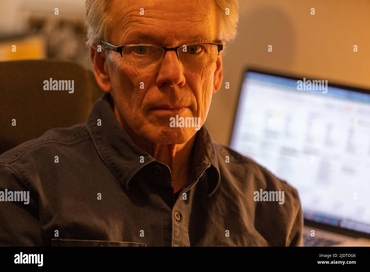 Ritratto dell'uomo anziano con il computer portatile sullo sfondo Foto Stock
