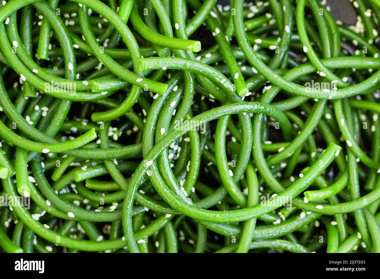 Frecce fresche all'aglio verde con semi di sesamo in primo piano. Cucina asiatica. Ingredienti per cibo. Vista dall'alto Foto Stock