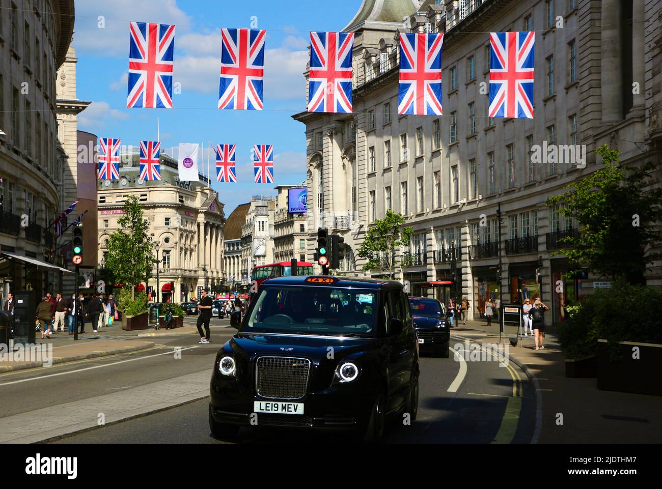Guardando verso Piccadilly Circus da Regent Street Londra Inghilterra Regno Unito, con le celebrazioni per il giubileo Platinum Union Jacks e un taxi nero giugno 2022 Foto Stock
