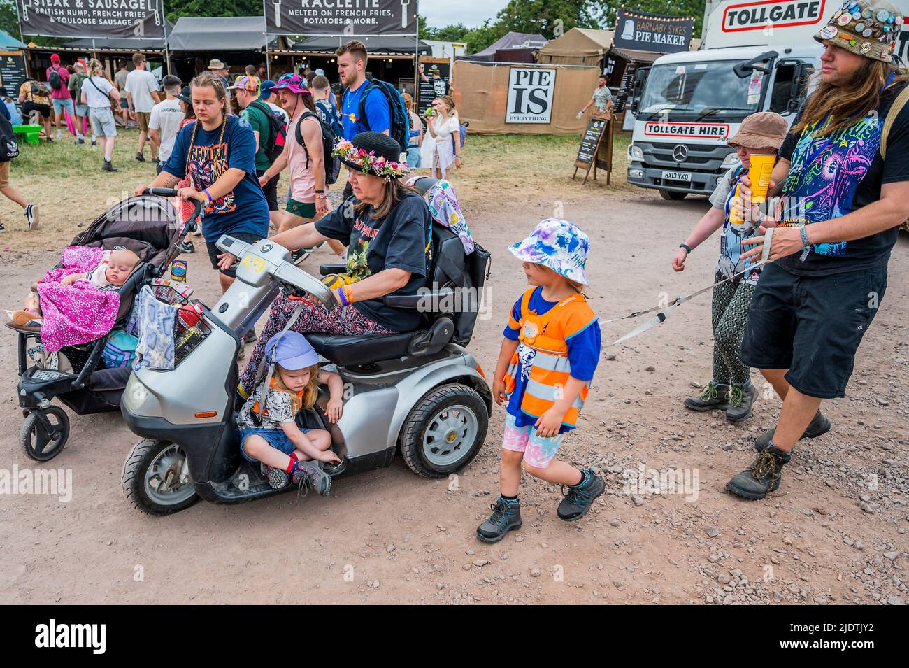 Glastonbury, Regno Unito. 23rd giugno 2022. Diverse generazioni di una famiglia si muovono intorno con una varietà di trasporto e un bambino si avvale del buggy elettrico - il Glastonbury Festival 50th 2022, Worthy Farm. Glastonbury, Credit: Guy Bell/Alamy Live News Foto Stock