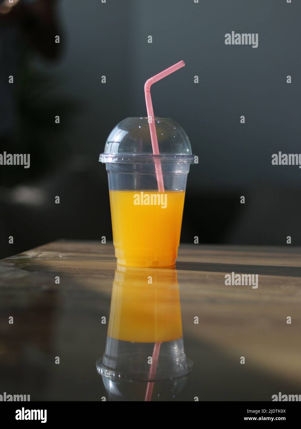 Bicchieri da succo gialli o bicchieri monouso in plastica con cannucce sul tavolo sfondo sfocato Summer fotografia concetto di scatto Foto Stock